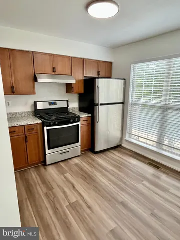 a kitchen with wooden cabinets and a stove top oven