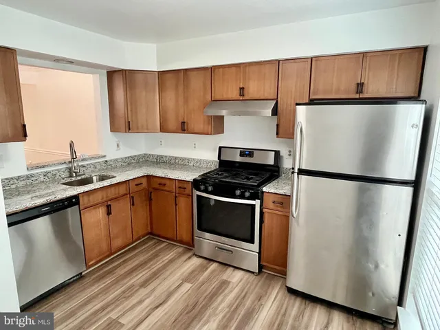 a kitchen with a refrigerator sink and cabinets