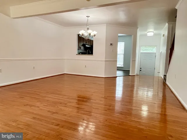 a view of a room with wooden floor and chandelier