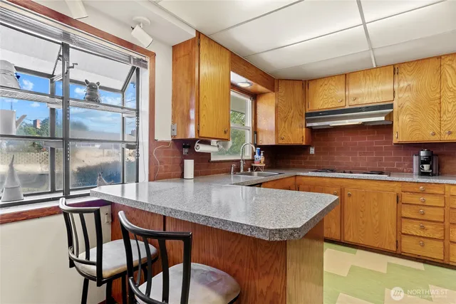 a kitchen with a sink a counter top space and living room filled with furniture