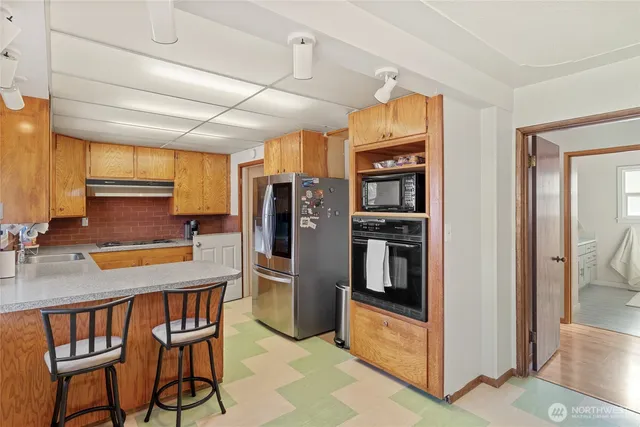 a kitchen with stainless steel appliances granite countertop a refrigerator a stove and a sink with dishwasher