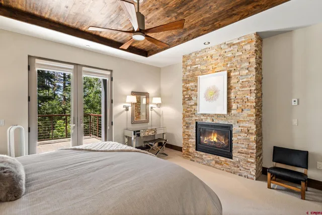 a bedroom with a bed a fireplace and a flat tv screen
