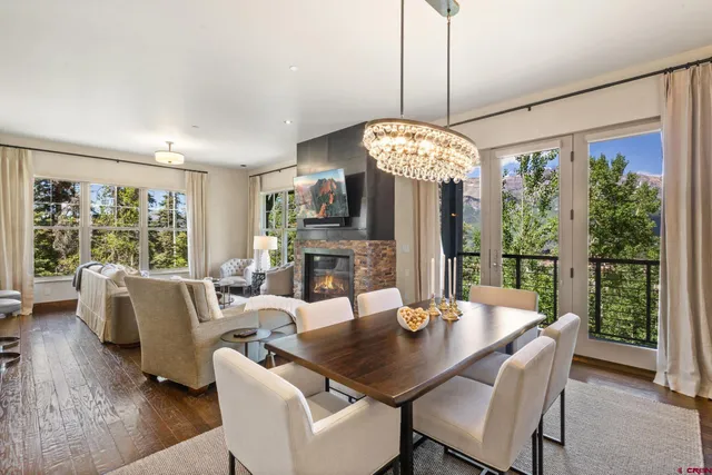 a dining room with furniture a chandelier and wooden floor