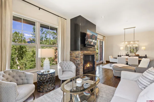 a living room with furniture fireplace and a large window