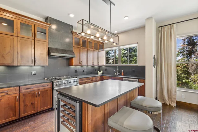 a kitchen with a stove a sink a counter space and wooden floor