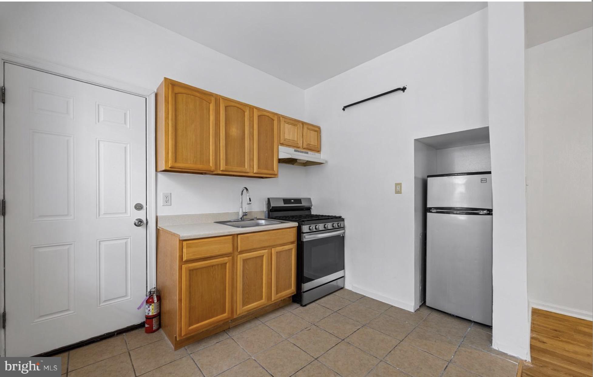 3800 Spring Garden Street, Unit 1 Philadelphia, PA 19104 - Photo 2 of 10 a kitchen with stainless steel appliances granite countertop a refrigerator and a stove