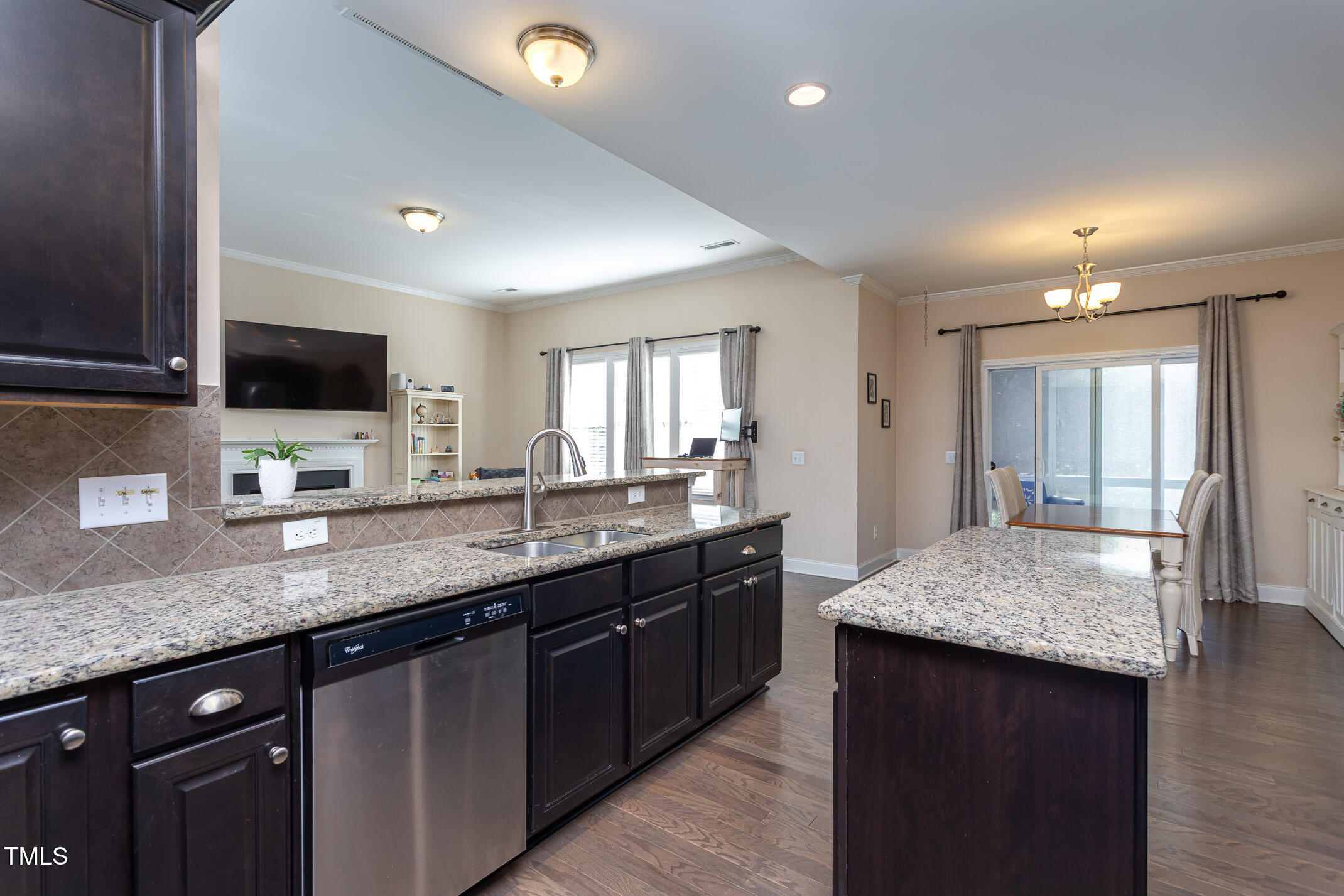 2411 Cattail Pond Drive Zebulon, NC 27597 - Photo 12 of 37 a kitchen with granite countertop kitchen island a sink and a wooden floor