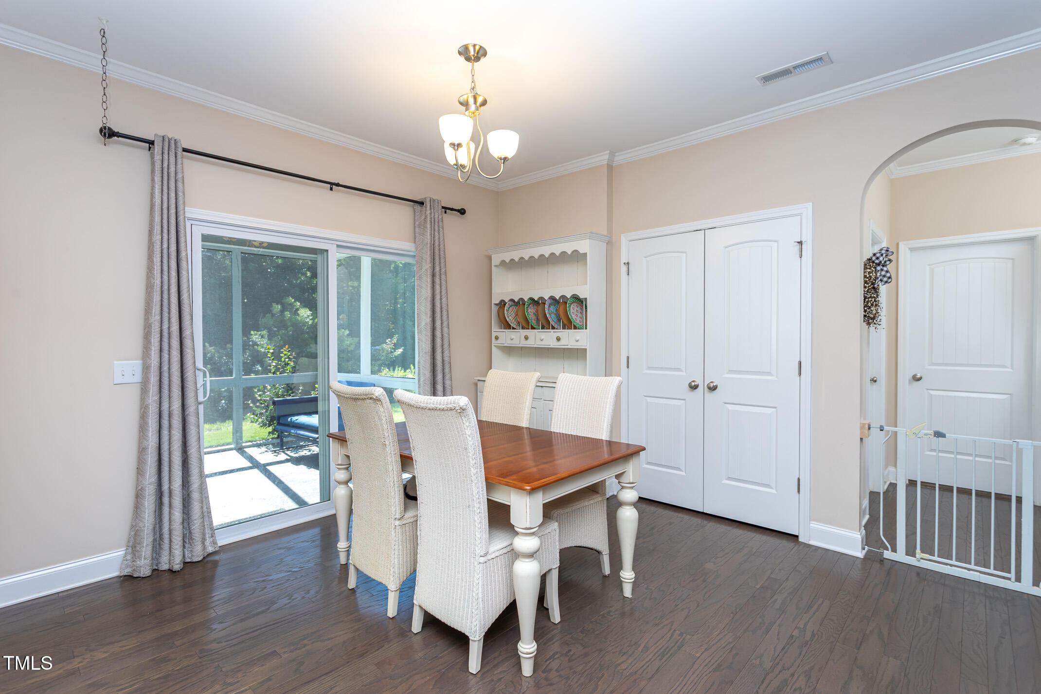 2411 Cattail Pond Drive Zebulon, NC 27597 - Photo 13 of 37 a dining room with wooden floor a chandelier a wooden table and chairs