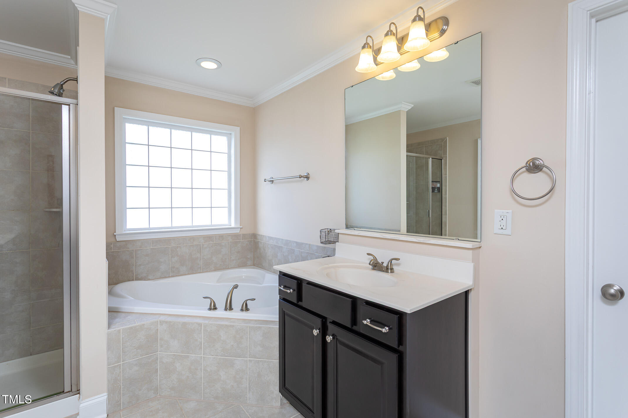 2411 Cattail Pond Drive Zebulon, NC 27597 - Photo 16 of 37 a bathroom with a tub a sink and a mirror