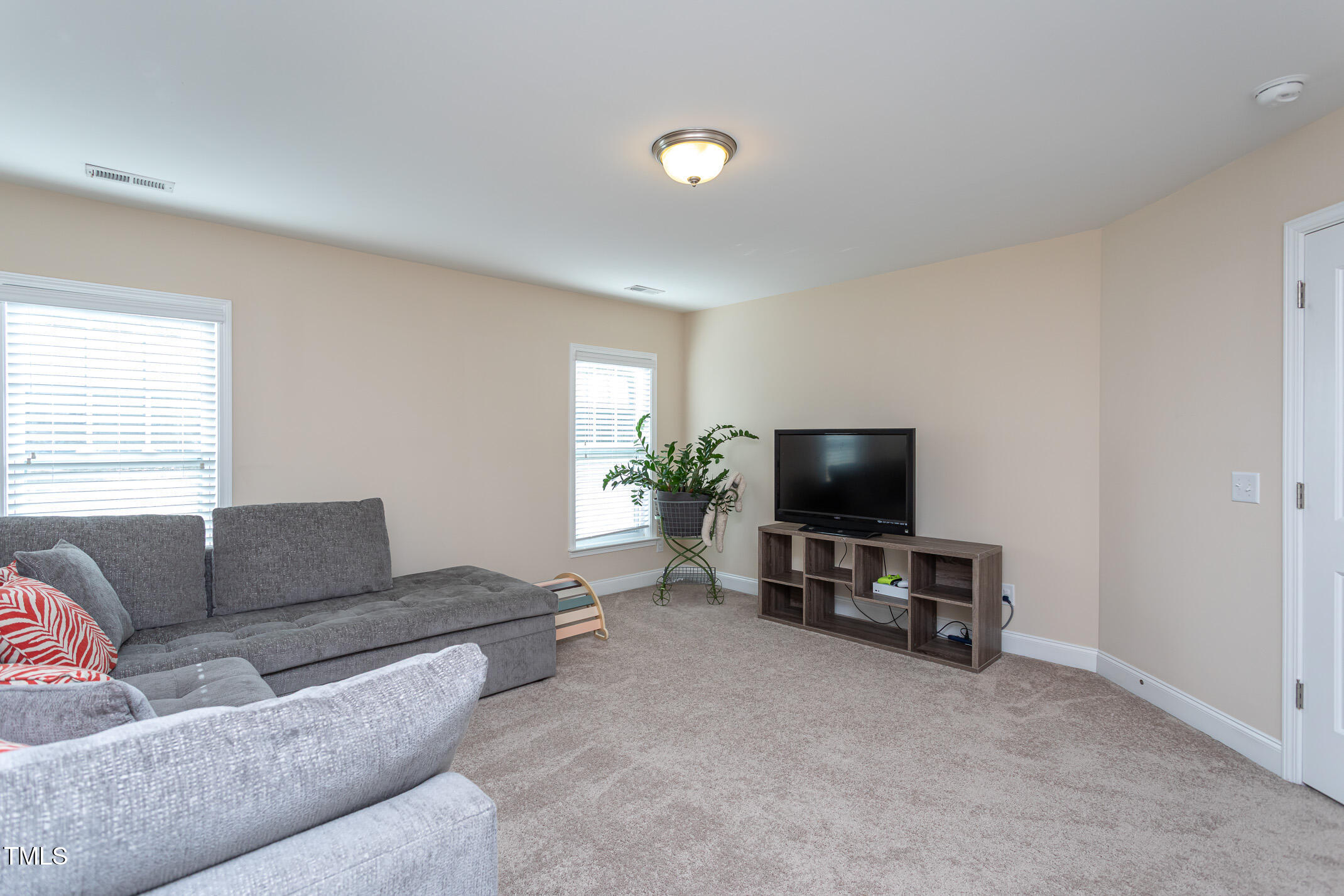2411 Cattail Pond Drive Zebulon, NC 27597 - Photo 26 of 37 a living room with furniture and a flat screen tv