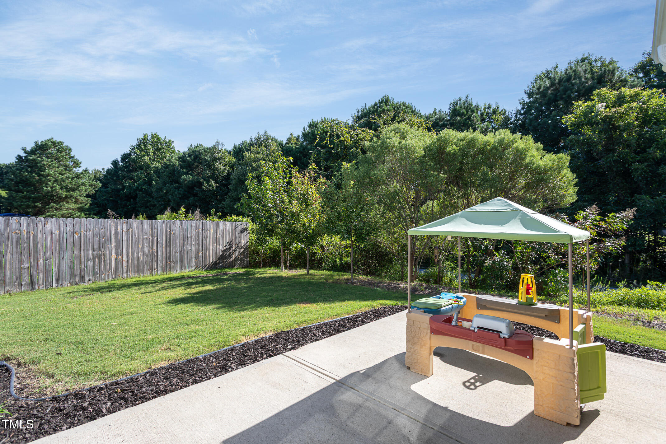 2411 Cattail Pond Drive Zebulon, NC 27597 - Photo 31 of 37 a view of a table and chairs under an umbrella