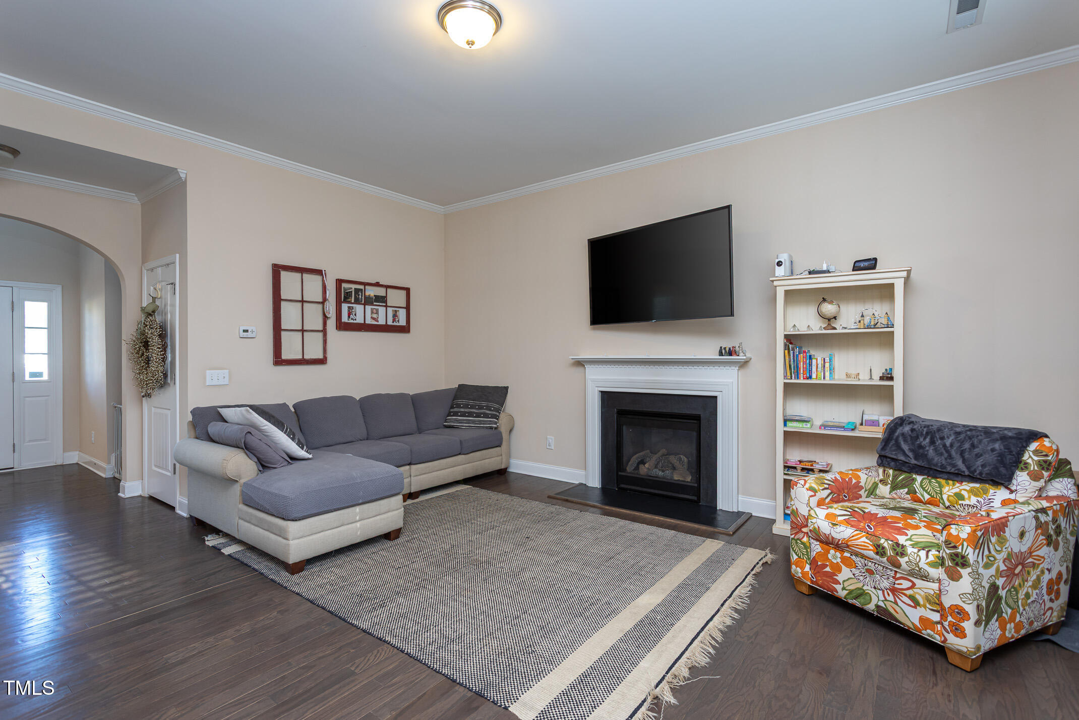 2411 Cattail Pond Drive Zebulon, NC 27597 - Photo 6 of 37 a living room with furniture a flat screen tv and a fireplace