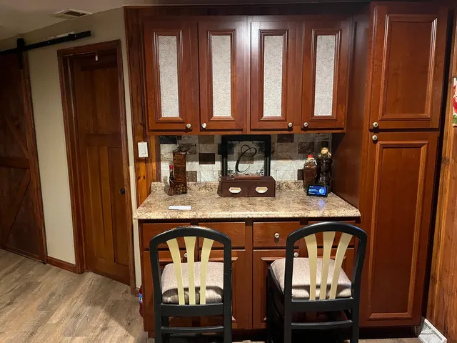 a kitchen with stainless steel appliances granite countertop a refrigerator a sink and wooden cabinets