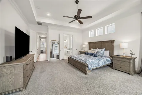 a spacious bedroom with a bed and a flat screen television