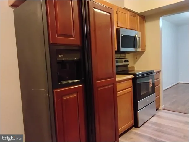 a kitchen with stainless steel appliances granite countertop a refrigerator and a microwave