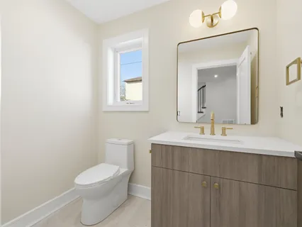 a bathroom with a toilet a sink and mirror