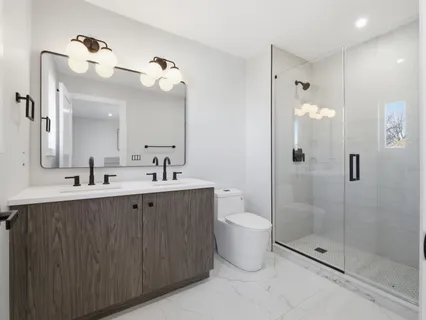 a bathroom with a double vanity sink mirror and shower
