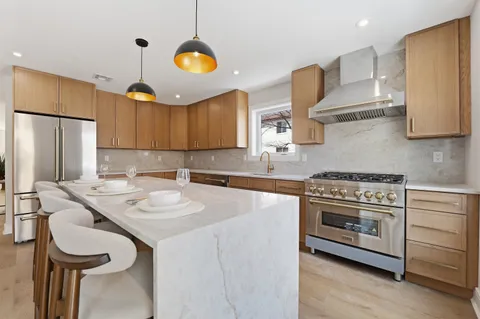 a kitchen with stainless steel appliances granite countertop a sink a stove and a refrigerator