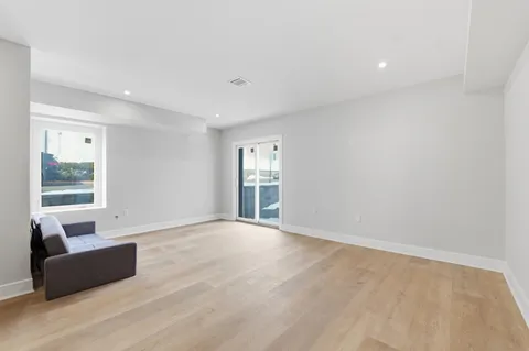 a view of a big room with wooden floor and windows
