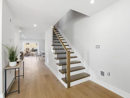 a view of a hallway with wooden floor and stairs