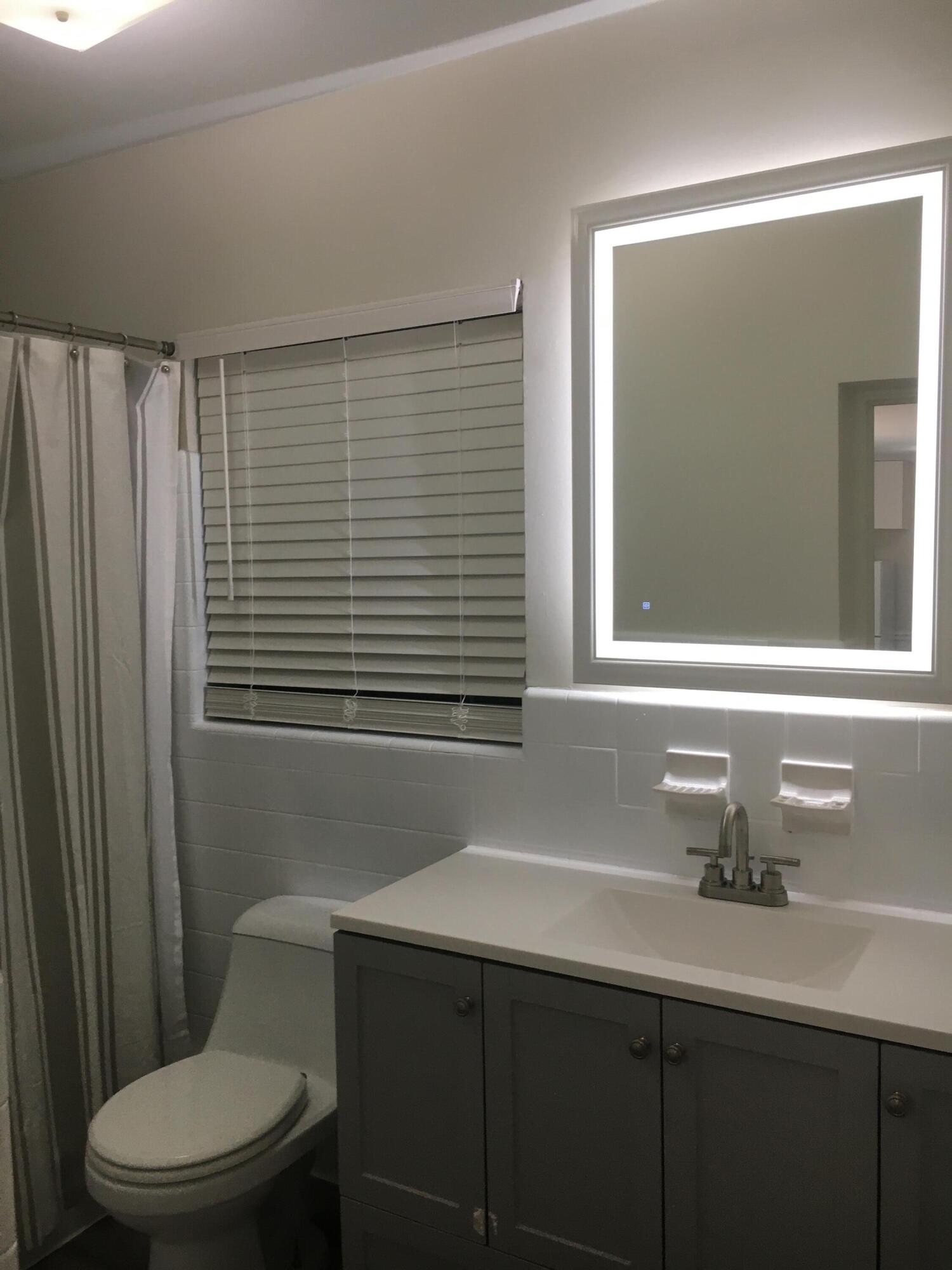1140 Hernando Street Fort Pierce, FL 34949 - Photo 11 of 37 a bathroom with a sink a toilet and a mirror