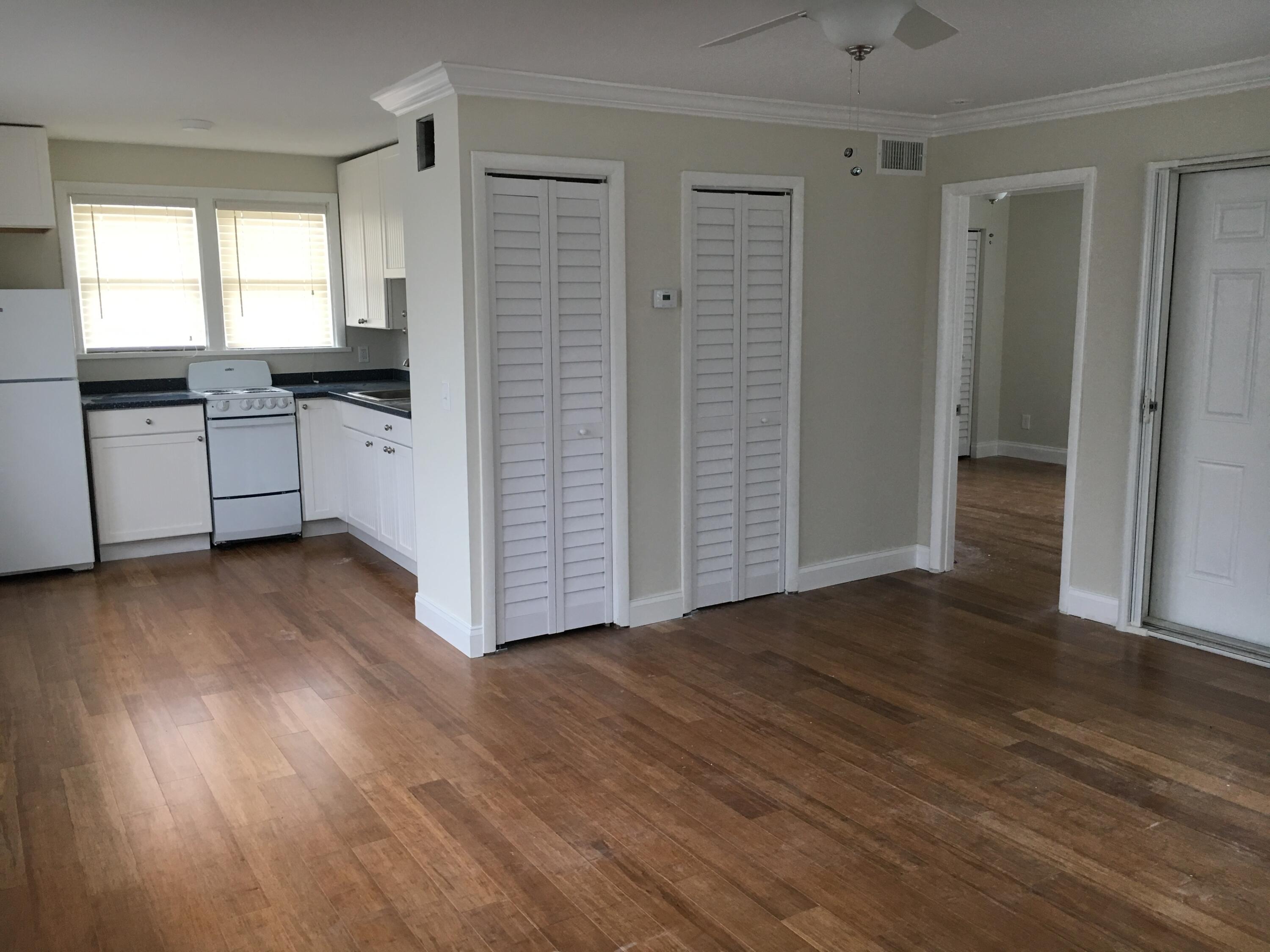 1140 Hernando Street Fort Pierce, FL 34949 - Photo 26 of 37 an empty room with wooden floor cabinet and windows
