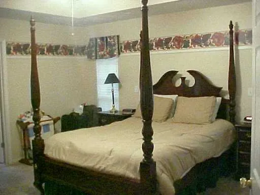 a bed sitting in a bedroom next to a window