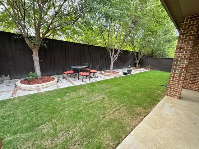 a view of a backyard with table and chairs and potted plants