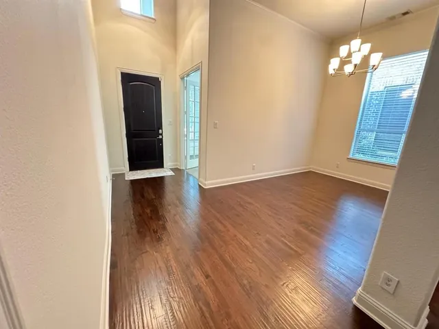 an empty room with wooden floor and staircase