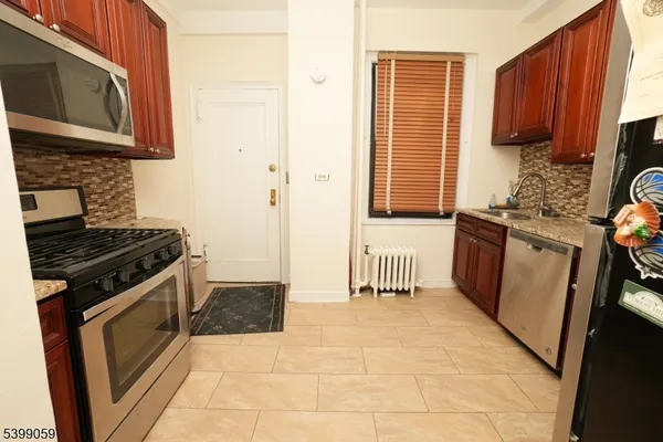a kitchen with stainless steel appliances granite countertop a stove a sink and a microwave