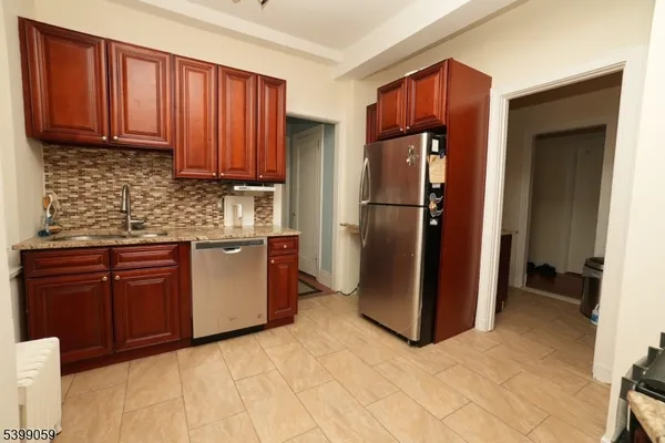 a kitchen with stainless steel appliances granite countertop a refrigerator and a sink