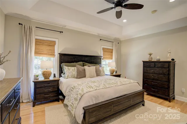 a bedroom with a bed a dresser and a chandelier