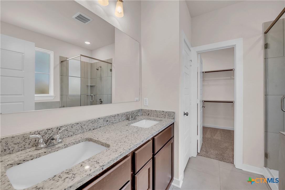 262 Wind Ridge Drive Copperas Cove, TX 76522 - Photo 11 of 30 a bathroom with a granite countertop sink and a mirror