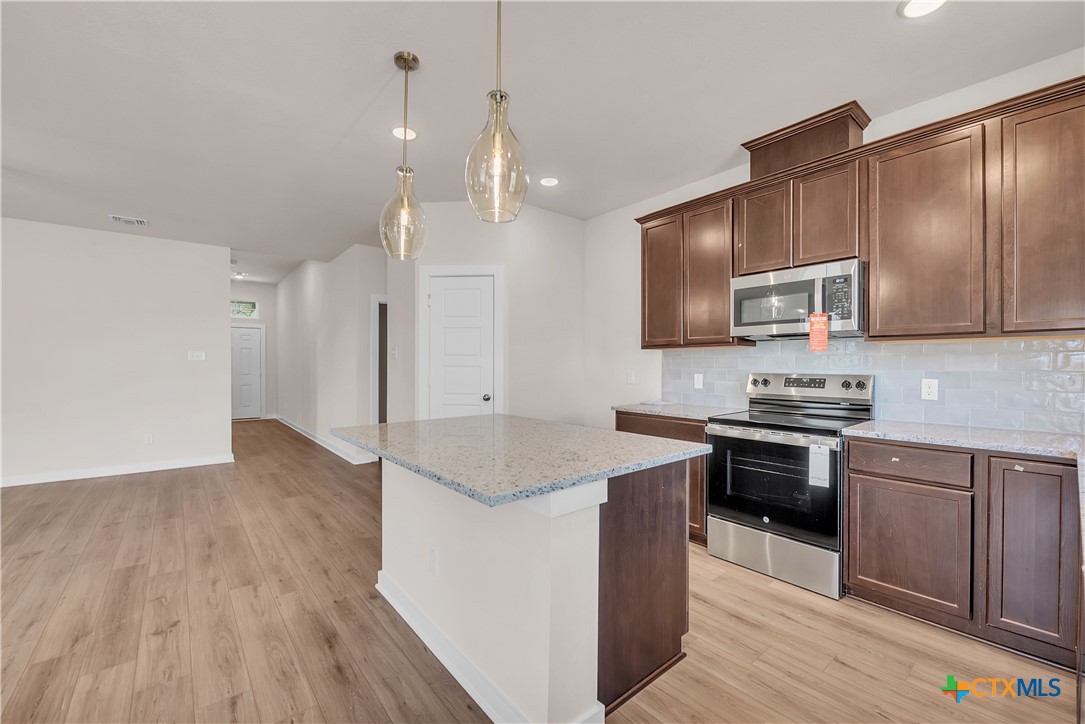 262 Wind Ridge Drive Copperas Cove, TX 76522 - Photo 22 of 30 a kitchen with stainless steel appliances granite countertop a sink stove and refrigerator