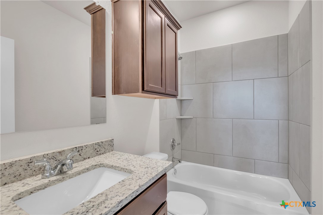 262 Wind Ridge Drive Copperas Cove, TX 76522 - Photo 5 of 30 a bathroom with a granite countertop sink and a bathtub