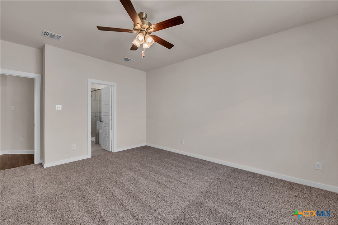 262 Wind Ridge Drive Copperas Cove, TX 76522 - Photo 10 of 30 an empty room with a chandelier fan and windows