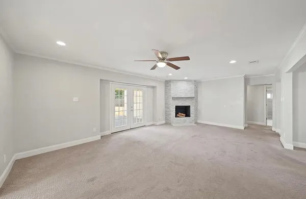 an empty room with windows and ceiling fan