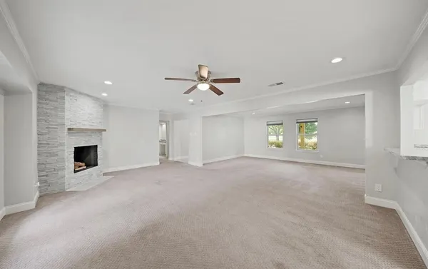 a view of an empty room with a fireplace and a window