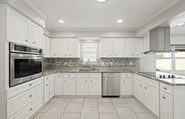 a kitchen with granite countertop white cabinets white stainless steel appliances with a sink and dishwasher