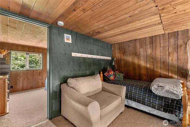 a bed sitting in a spacious bedroom next to a window