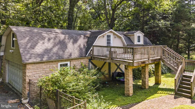 a bedroom with a large bed couch and two windows