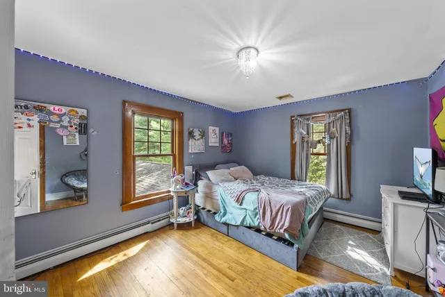 a house that is sitting in the grass with large trees
