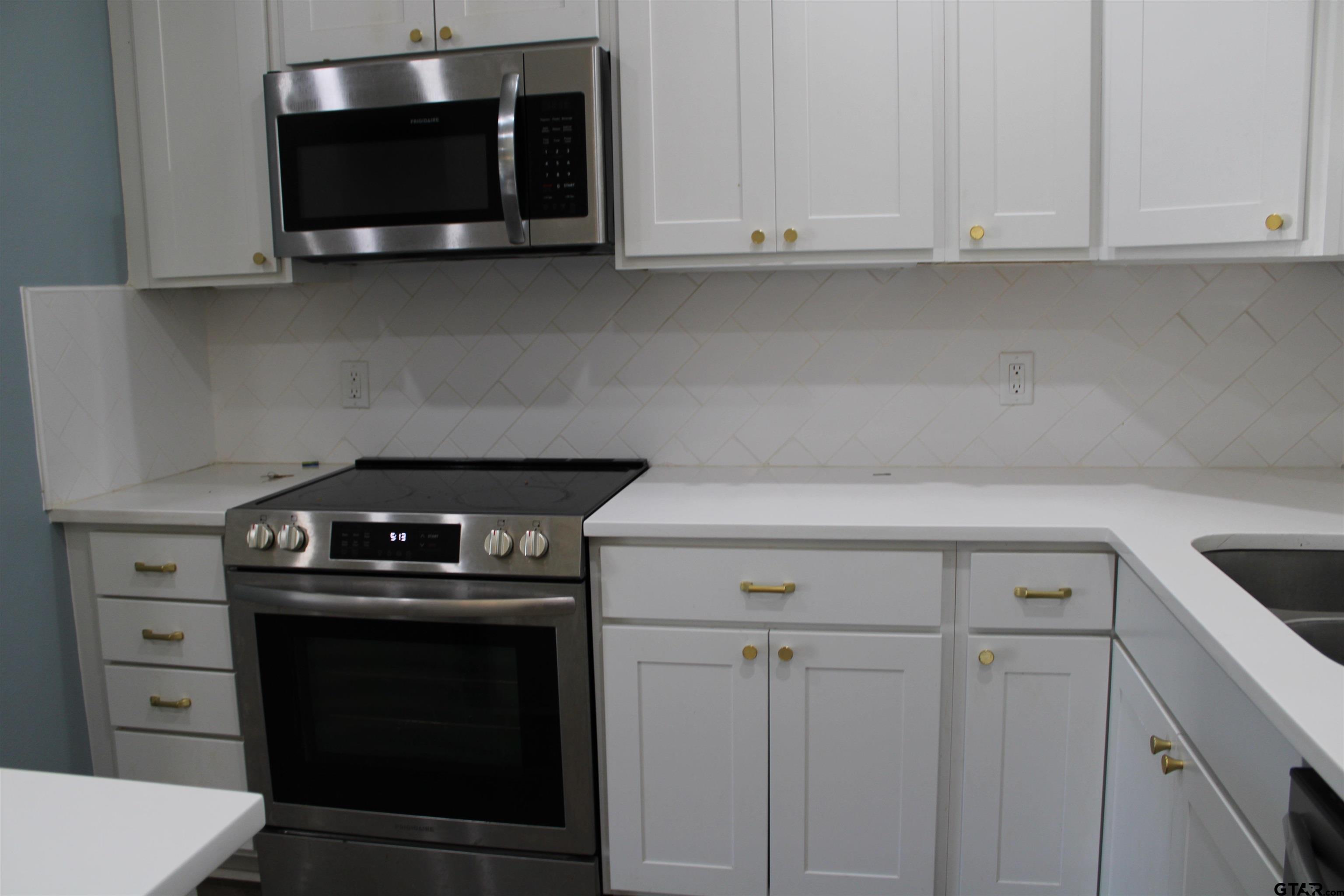 14965 Turtle Crk Rnch Road Flint, TX 75762 - Photo 5 of 26 a kitchen with white cabinets and black appliances