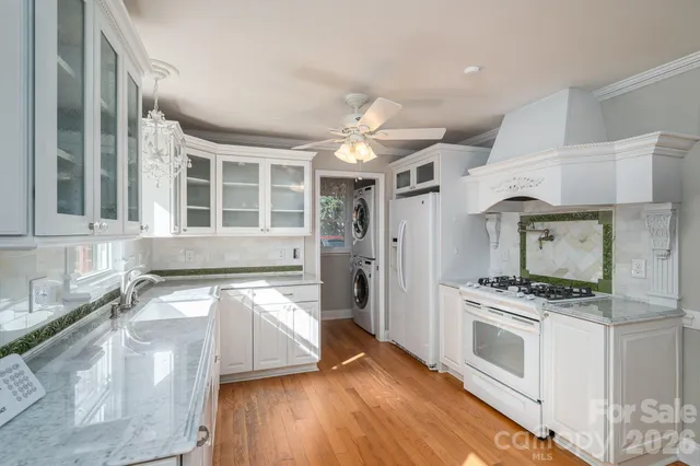 a kitchen with granite countertop a stove a sink and a refrigerator