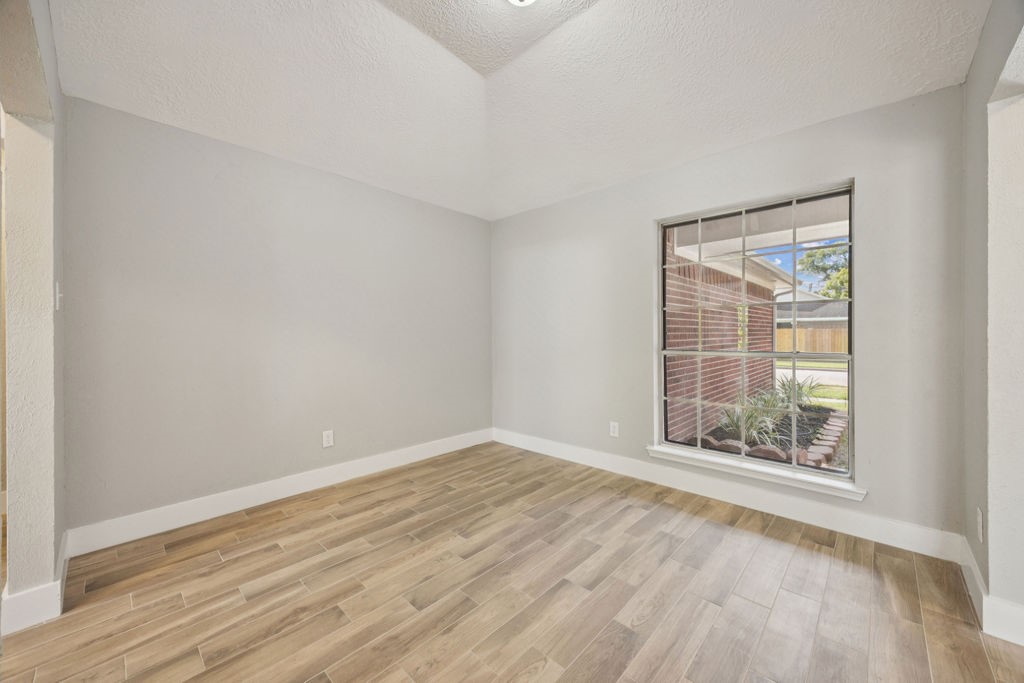 2942 Waterloo Road Pearland, TX 77581 - Photo 12 of 22 an empty room with wooden floor and windows