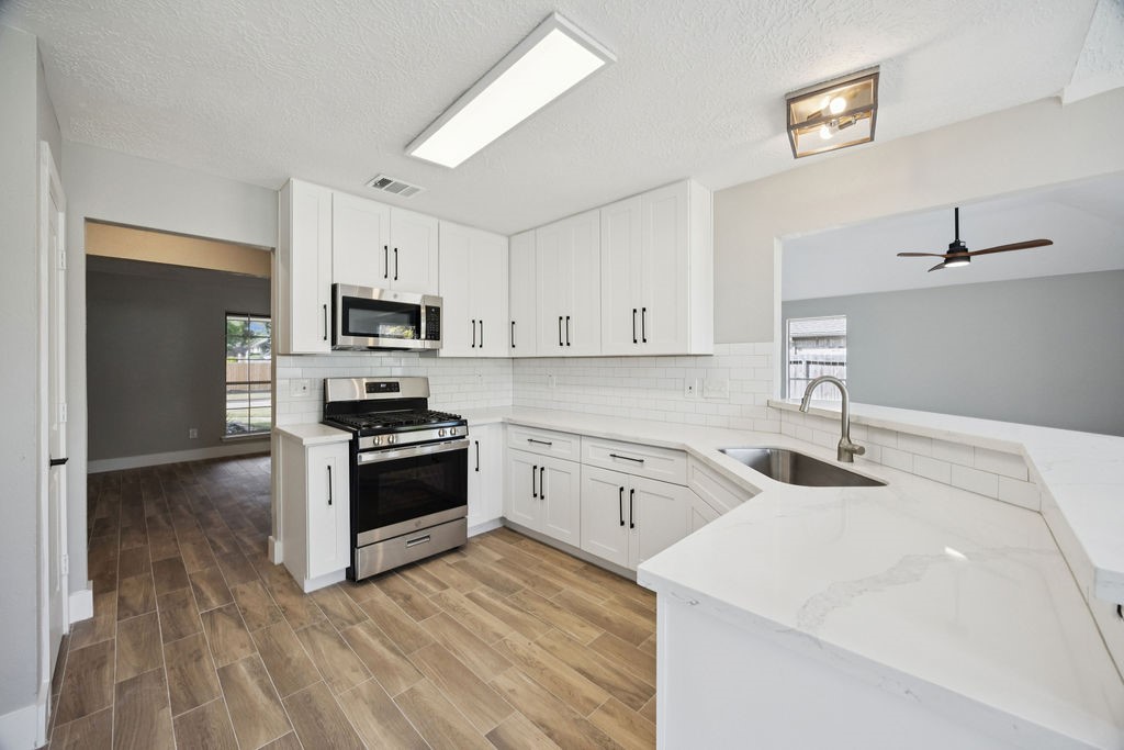 2942 Waterloo Road Pearland, TX 77581 - Photo 7 of 22 a kitchen with white cabinets appliances and sink