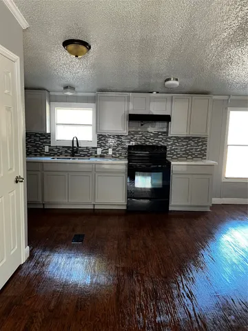 a kitchen with stainless steel appliances granite countertop a stove and a wooden floors