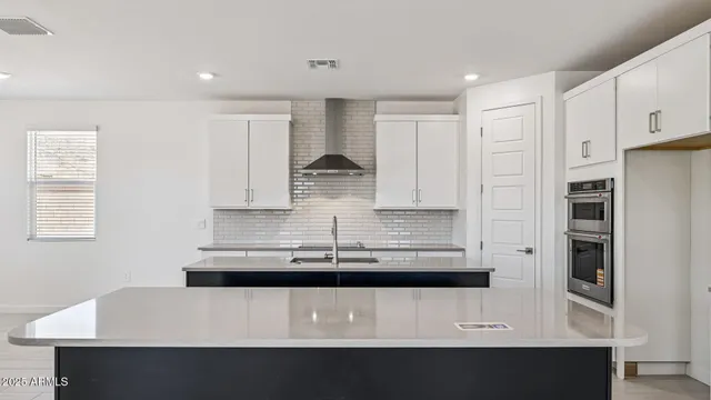 a kitchen with kitchen island granite countertop a sink counter top space appliances and cabinets