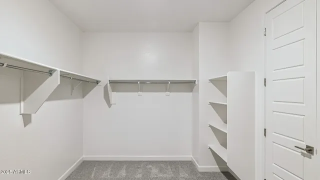 a view of an empty room with kitchen and a sink