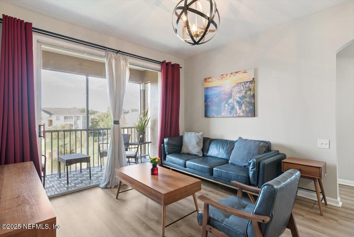 7990 Baymeadows Road East, Unit 913 Jacksonville, FL 32256 - Photo 11 of 70 a living room with furniture a couch and a floor to ceiling window